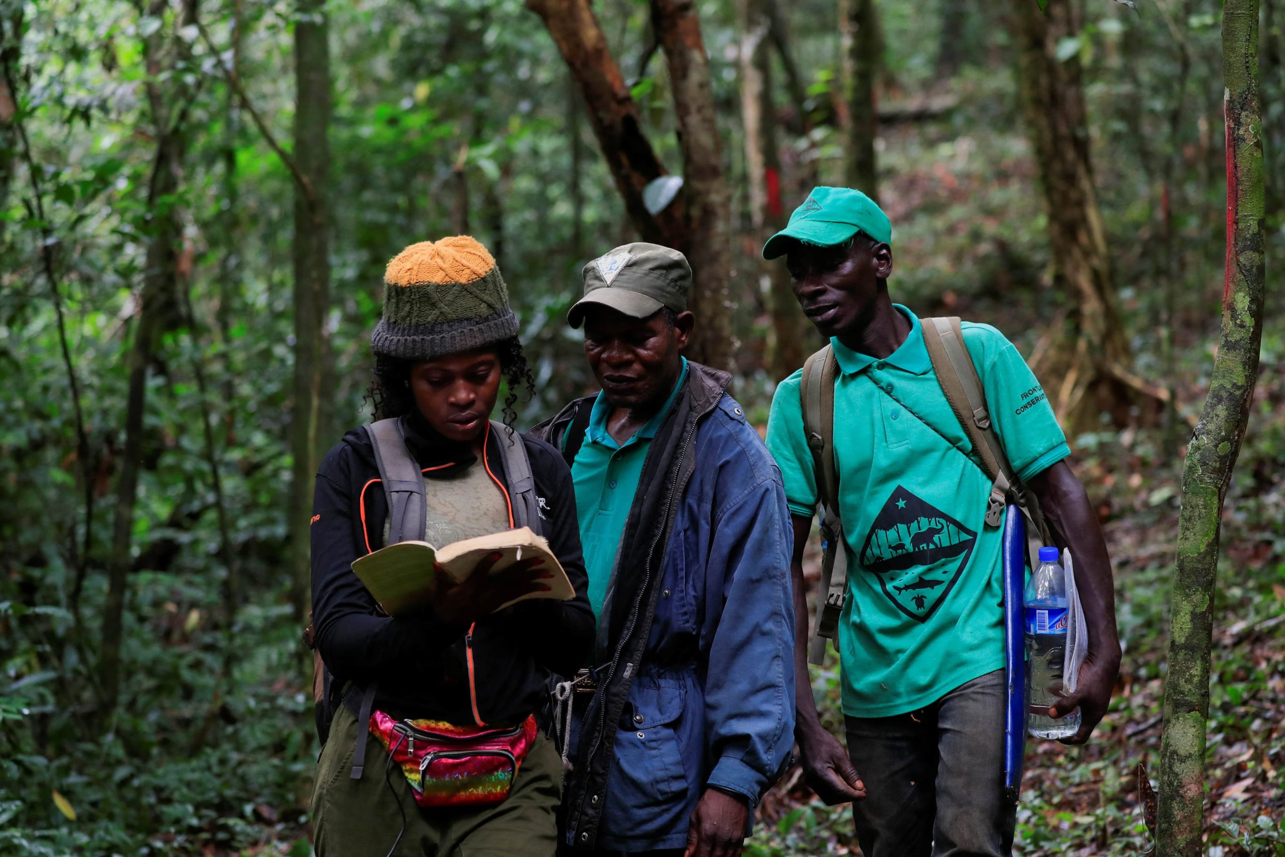 A group of biologists check a book in the forest of Liberia