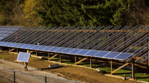 A worker carrying a solar panel for renewable energy installation in Oregon, US.