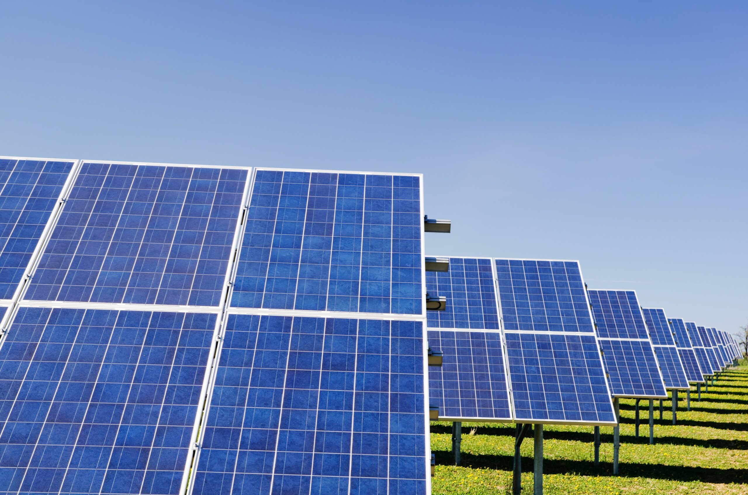 Three solar panels in a field.